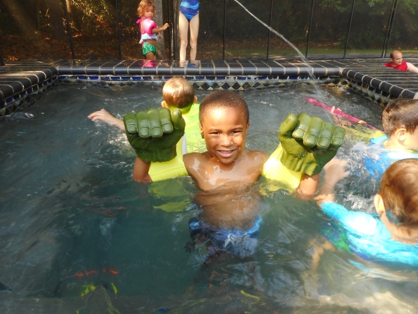 Boy in pool with Hulk Hands